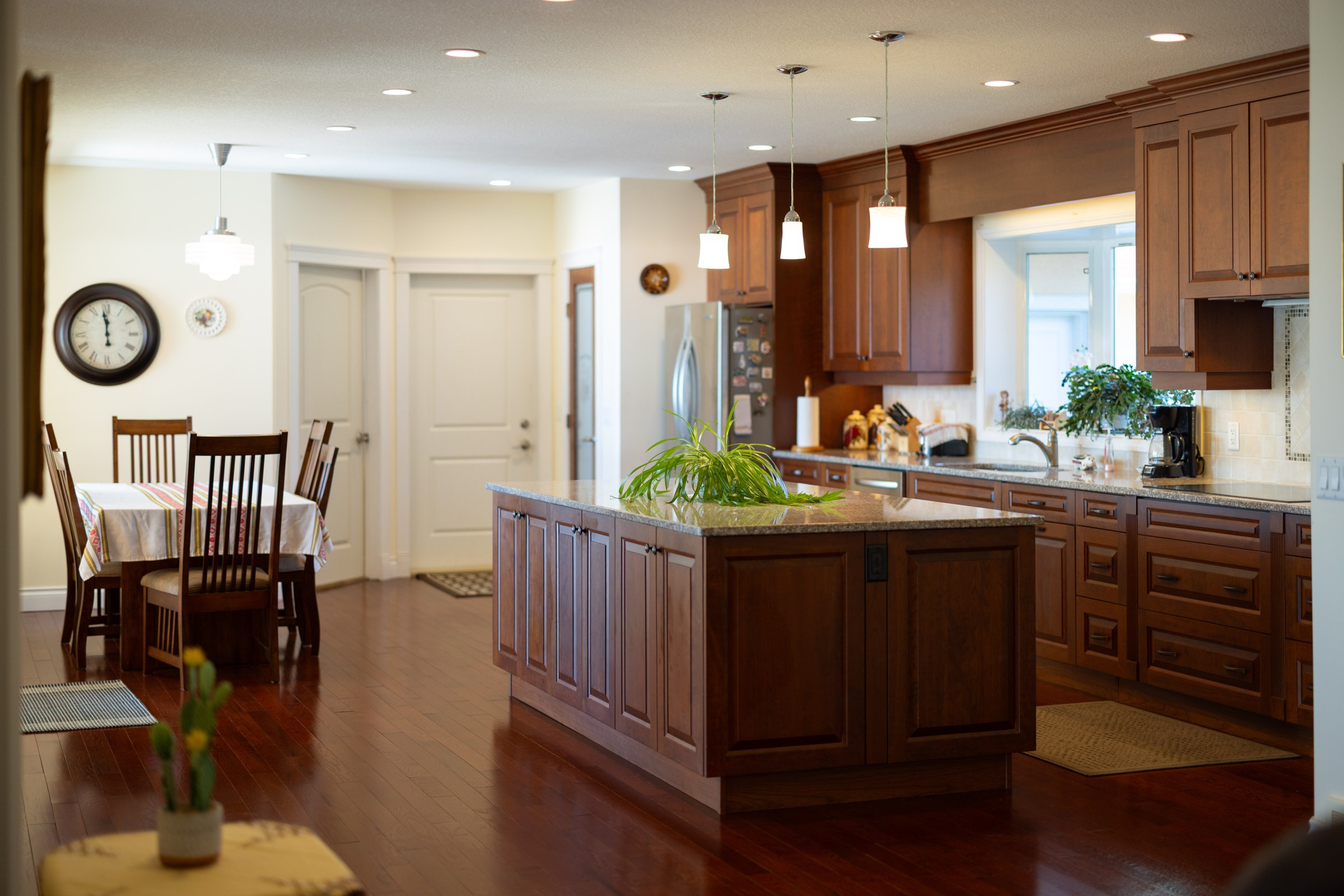 The main kitchen, with island, wood cabinetry and dining area