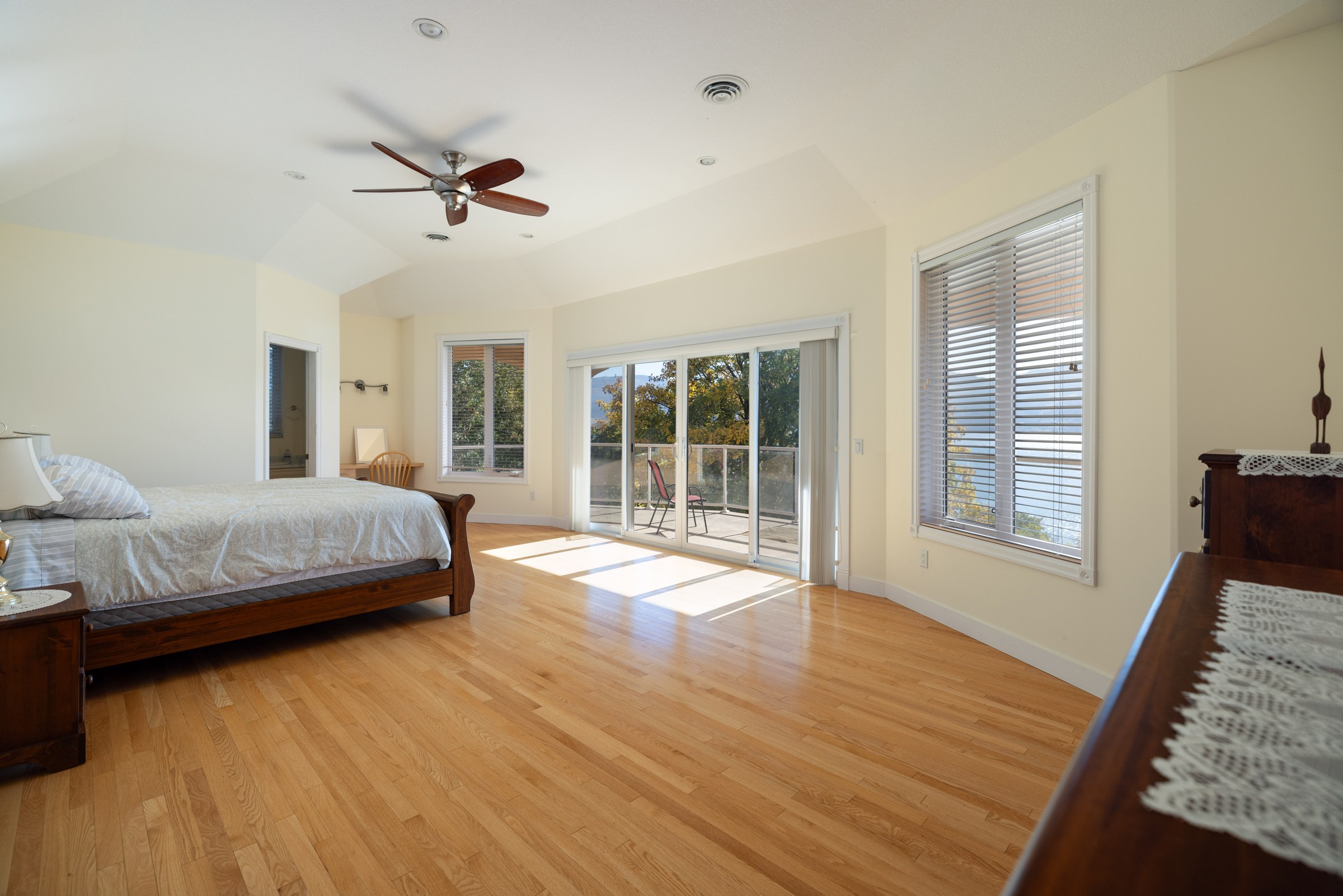 The primary suite, a large bedroom with doors opening to its own deck